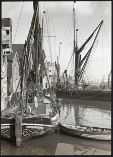 Sailed fishing vessels moored beside timber warehouses at Rochester, Medway, 1925-1935. Creator: J Dixon Scott