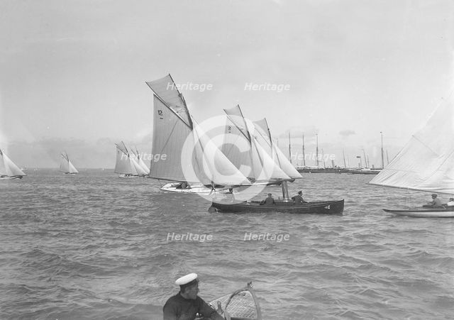 Sailing yachts cross start line. Creator: Kirk & Sons of Cowes.