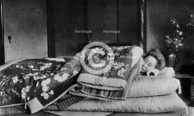 'Saki, the housekeeper sleeps on a mattress with hard pillow under a quilted kimono', c1900, (1921). Artist: Julian Leonard Street.