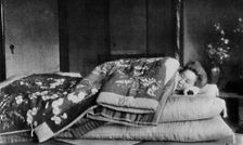 Saki, the housekeeper sleeps on a mattress with hard pillow under a quilted kimono c1900, (1921). Artist: Julian Leonard Street