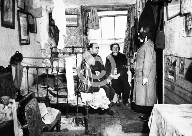 Salvation Army visiting a resident in Notting Hill, London, c1900. Artist: Unknown.