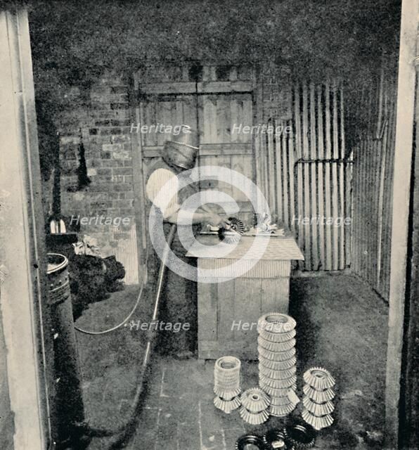 'Sand-blasting Gear Wheels', c1917. Artist: Unknown.