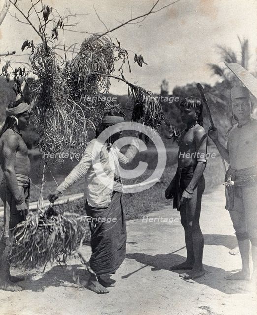 Sarawak: a Kayan woman dancing with the head of an enemy, c1900. Creator: Unknown.