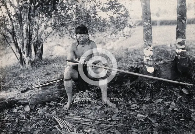 Sarawak: a Kenyah worker tying a spearhead to a blowpipe, c1900. Creator: Unknown.