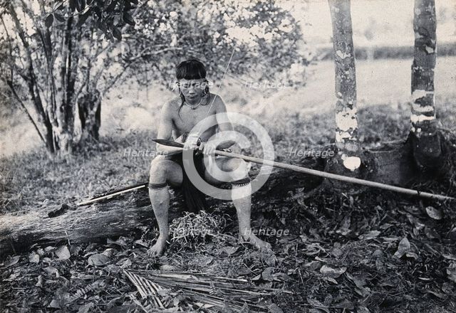 Sarawak: a Kenyah worker tying a spearhead to a blowpipe, c1900. Creator: Unknown.
