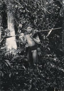Sarawak: a Kenyah hunter with blowpipe and dead animal, c1900. Creator: Unknown