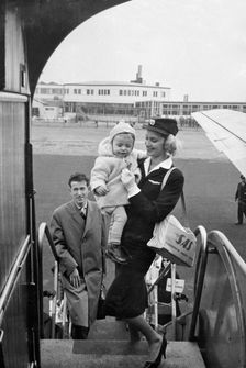 SAS stewardess carrying a baby onto a plane, Bulltofta airport, Malmö, Sweden, 1950. Creator: Torkel Lindeberg