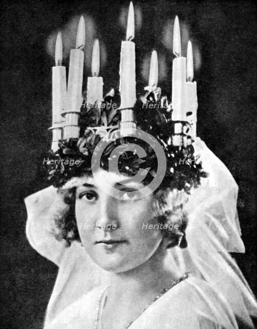 Scandinavian girl wearing candle headdress on St Lucy's Day, 1936.Artist: Fox