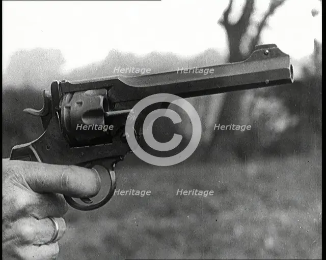 Scene from the Feature Film 'The White Sheik'. A Pistol Being Held By a Man With His Finger...,1920s Creator: British Pathe Ltd.