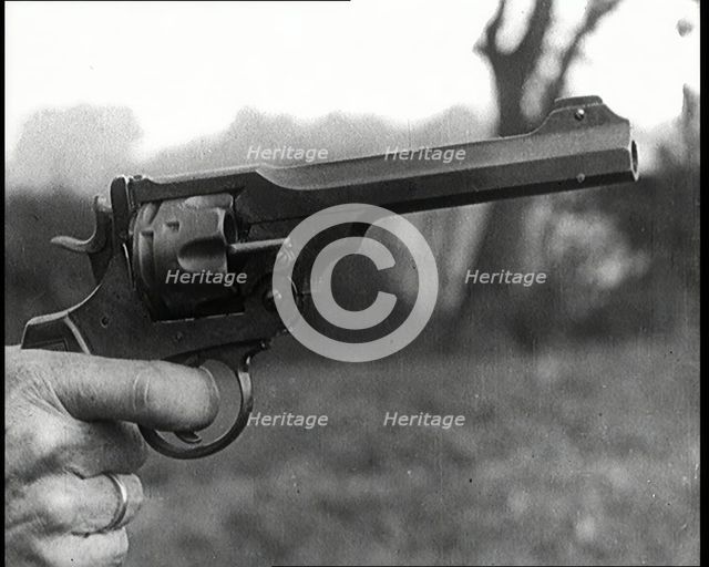 Scene from the Feature Film 'The White Sheik'. A Pistol Being Held By a Man With His Finger...,1920s Creator: British Pathe Ltd.