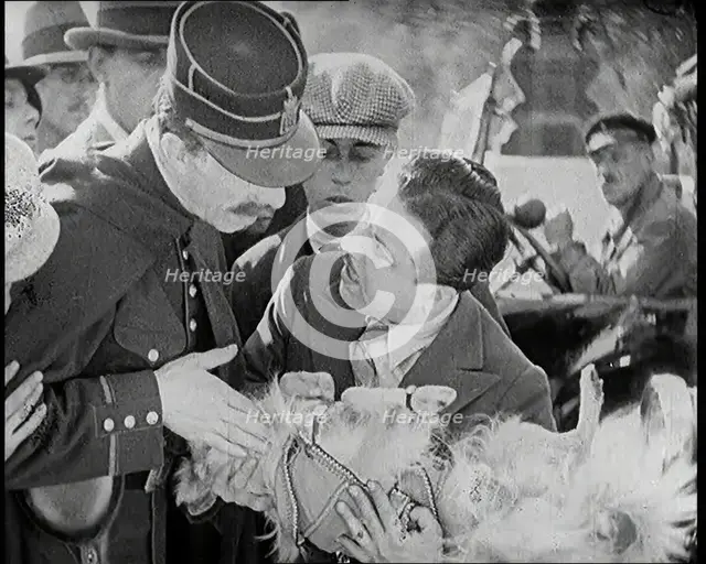 Scene from the Film 'The Compulsory Husband': Monty Banks Holding a Dog That He Has Run Over, 1920s. Creator: British Pathe Ltd.