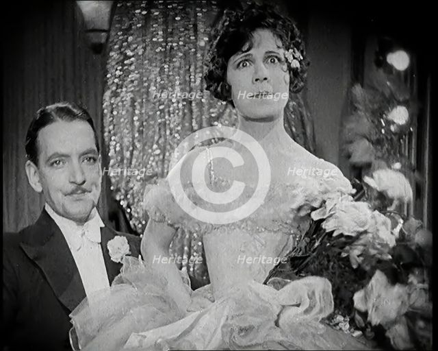 Scene from the Film 'The Compulsory Husband':  a Female Actor Sitting on a Male Actors Lap, 1920s. Creator: British Pathe Ltd.