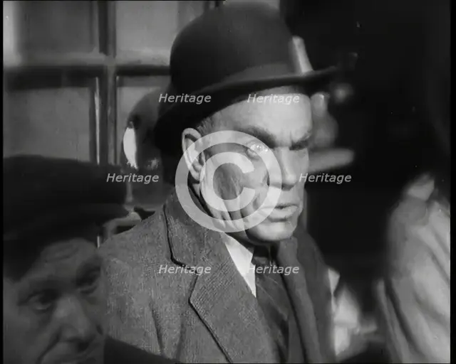 Scene from the Film 'The Informer':  Male Actor Looking at Money Being Thrown on the..., 1920s. Creator: British Pathe Ltd.
