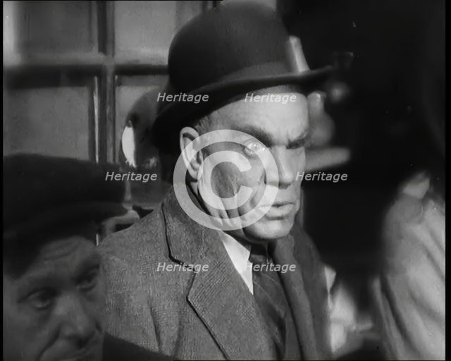 Scene from the Film 'The Informer':  Male Actor Looking at Money Being Thrown on the..., 1920s. Creator: British Pathe Ltd.