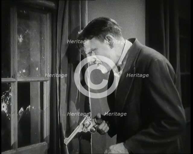 Scene from the Film 'The Informer':  Male Actor Shooting a Gun Out of a Window, 1920s. Creator: British Pathe Ltd.