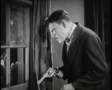 Scene from the Film The Informer': Male Actor Shooting a Gun Out of a Window, 1920s. Creator: British Pathe Ltd