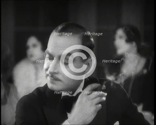 Scene from the Film 'Champagne': a Male Actor in a Nightclub Smoking a Cigarette, 1920s. Creator: British Pathe Ltd.