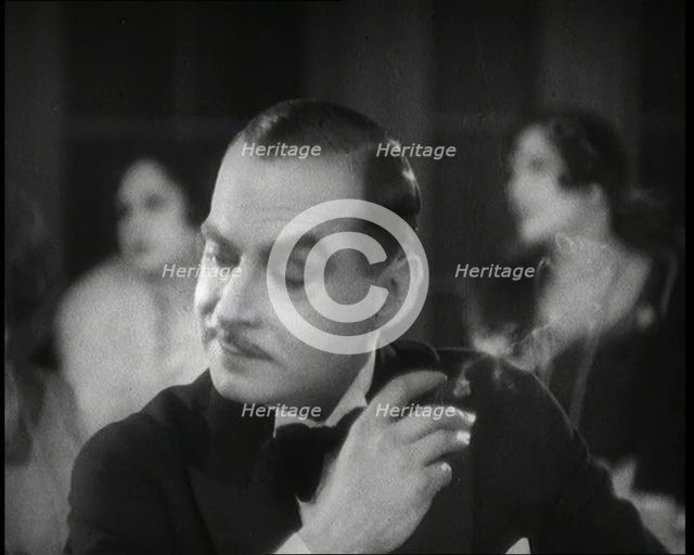 Scene from the Film 'Champagne': a Male Actor in a Nightclub Smoking a Cigarette, 1920s. Creator: British Pathe Ltd.