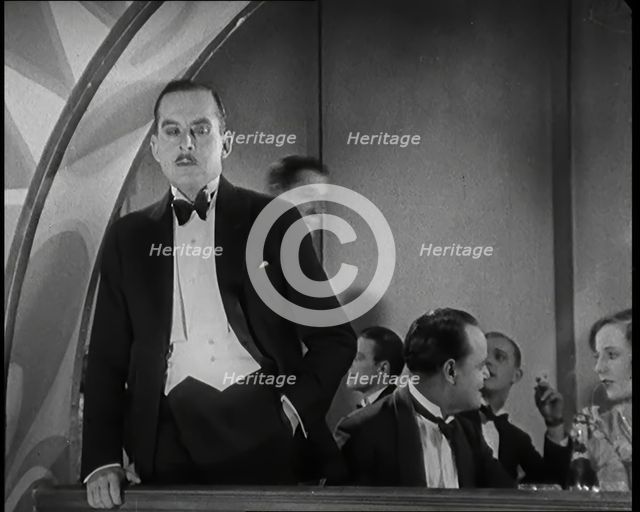 Scene from the Film 'Champagne': Male Actor Standing on a Balcony Overlooking the Nightclub...,1920s Creator: British Pathe Ltd.