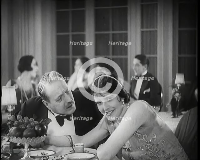 Scene from the Film 'Champagne': Two Actors Sitting at a Table in a Nightclub, 1920s. Creator: British Pathe Ltd.