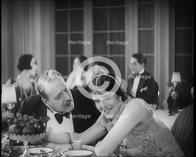 Scene from the Film 'Champagne': Two Actors Sitting at a Table in a Nightclub, 1920s. Creator: British Pathe Ltd.