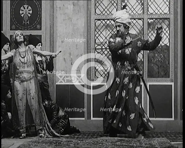 Scene from the Play 'Hassan': the Actor Henry Ainley in Full Costume Raising a Sword..., 1920s. Creator: British Pathe Ltd.