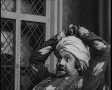 Scene from the Play Hassan': the Actor Henry Ainley in Full Costume Raising a Sword..., 1920s. Creator: British Pathe Ltd