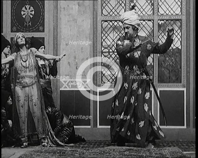 Scene from the Play 'Hassan': the Actor Henry Ainley in Full Costume Raising a Sword..., 1920s. Creator: British Pathe Ltd.