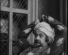 Scene from the Play Hassan': the Actor Henry Ainley in Full Costume Raising a Sword..., 1920s. Creator: British Pathe Ltd