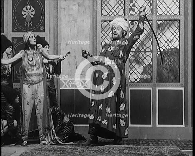 Scene from the Play 'Hassan': the Actor Henry Ainley in Full Costume Raising a Sword..., 1920s. Creator: British Pathe Ltd.