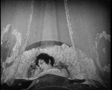 Scene from a 1920s Film. A Female Actor Sleeping in a Bed, 1920s. Creator: British Pathe Ltd