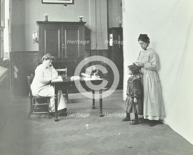 School nurse examining girls' hair for head lice, Chaucer School, London, 1911. Artist: Unknown.