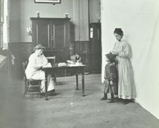 School nurse examining girls hair for head lice, Chaucer School, London, 1911