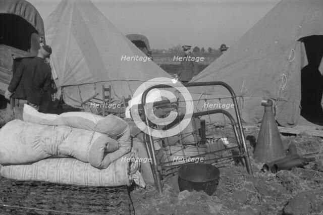 Setting up a tent in the camp for white flood refugees, Forrest City, Arkansas, 1937. Creator: Walker Evans.