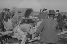 Setting up a tent in the camp for white flood refugees, Forrest City, Arkansas, 1937. Creator: Walker Evans