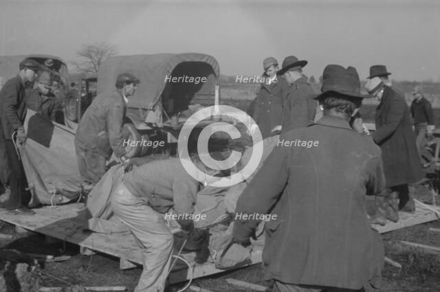 Setting up a tent in the camp for white flood refugees, Forrest City, Arkansas, 1937. Creator: Walker Evans.