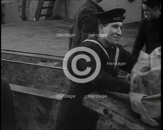 Several Male Crew, Including One from the Royal Navy, Inspecting the Cargo of a Large Vessel, 1939. Creator: British Pathe Ltd.