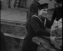Several Male Crew, Including One from the Royal Navy, Inspecting the Cargo of a Large Vessel, 1939. Creator: British Pathe Ltd