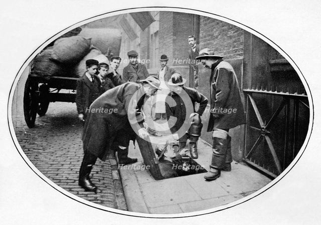 Sewermen going below, London, c1903 (1903). Artist: Unknown.