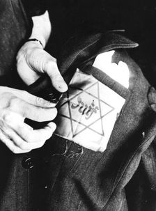 Sewing the yellow star identifying a Jew onto a jacket, German-occupied Paris, 1942