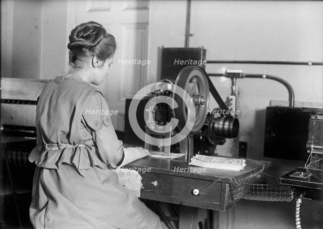 Seal of The United States - Stamping Bonds, 1917. Creator: Harris & Ewing.