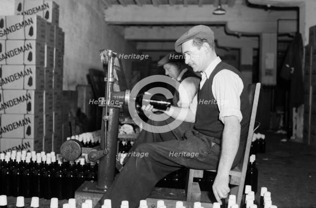 Sealing bottles of port wine at the Cutler Street warehouses, London, c1945-1965. Artist: SW Rawlings