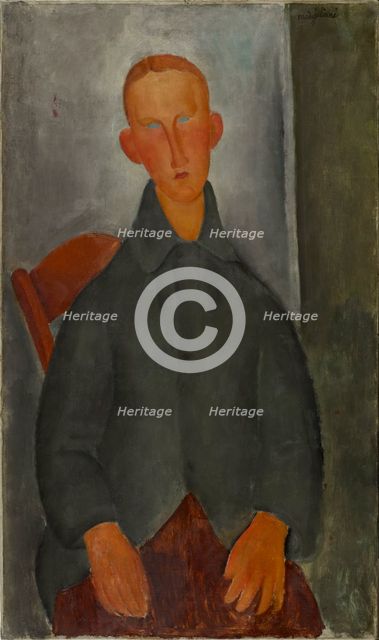 Seated boy with red hair and grey jacket.