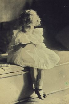 Seated girl reading a book, c1900. Creator: Eva Watson-Schutze