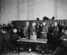 Sec. of the Navy Josephus Daniels drawing draft capsules, between 1910 and 1920. Creator: Harris & Ewing