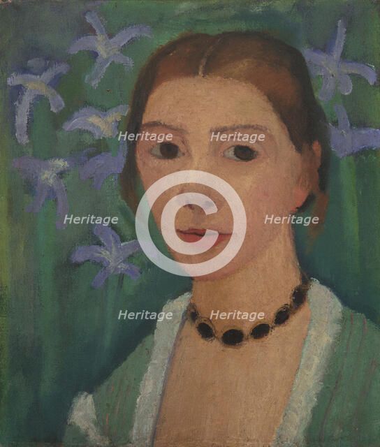 Self portrait in front of green background with blue irises, c. 1905.