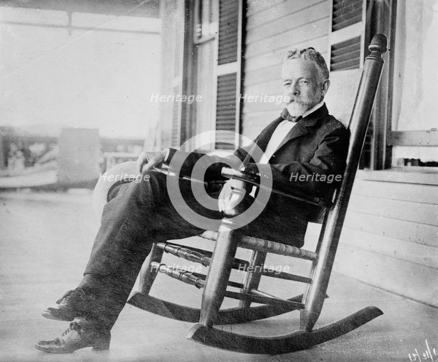 Sen. H.C. Lodge in rocker on porch, 1910. Creator: Bain News Service.