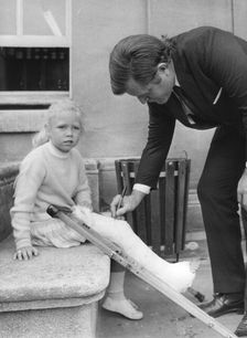Senator Edward Kennedy signs a girl's leg cast at Radcliffe Infirmary, Oxford, 1971. Creator: Unknown