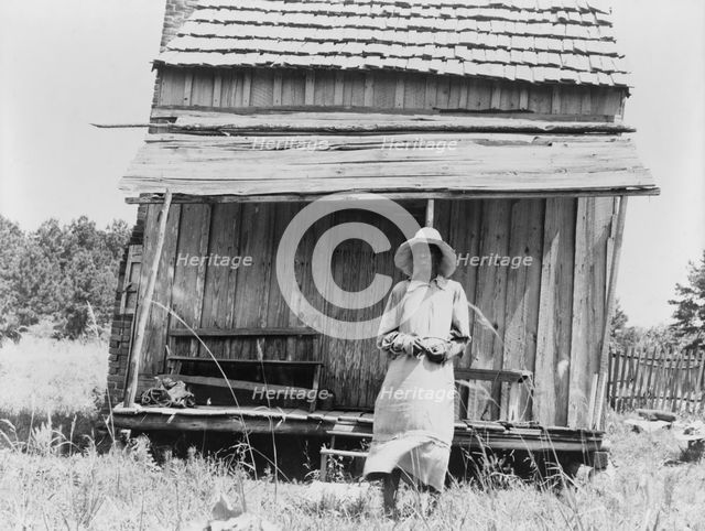 Sharecropper's cabin and sharecropper's wife, Ten miles south of Jackson, Mississippi, 1937. Creator: Dorothea Lange.