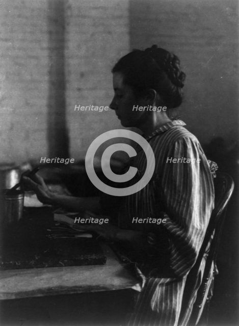 Shoe factories, Lynn, Mass.: woman seated at table, working in shoe factory, (1895?). Creator: Frances Benjamin Johnston.